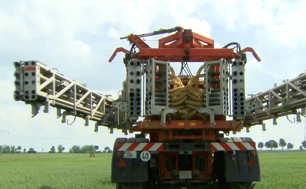 Rückansicht einer landwirtschaftlichen Sprühmaschine mit eingeklappten Auslegern auf einem Feld