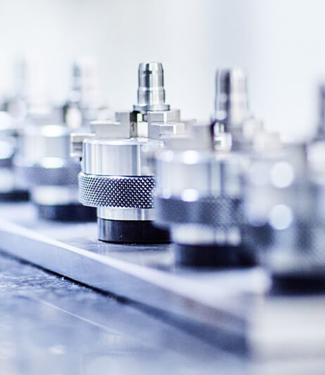 Präzisionsteile aus Metall in einer Fertigungslinie – Fokus auf hochglanzpolierte Bauteile.