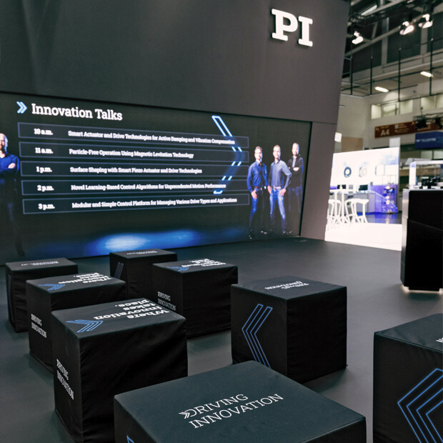 Große LED-Wand mit Innovation Talks und Sitzwürfeln mit „Driving Innovation“-Aufdruck.