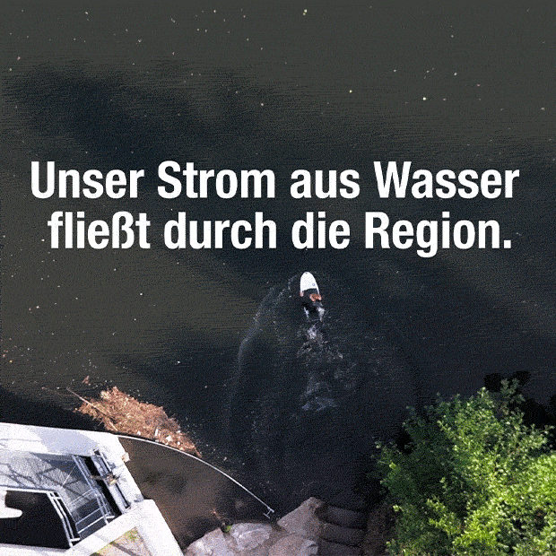 Surfer im Fluss von oben, darüber Schriftzug: „Unser Strom aus Wasser fließt durch die Region.“